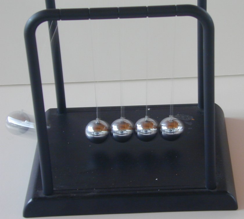Una bola del extremo izquierdo, en movimiento (borrosa), a punto de golpear a las otras cuatro.