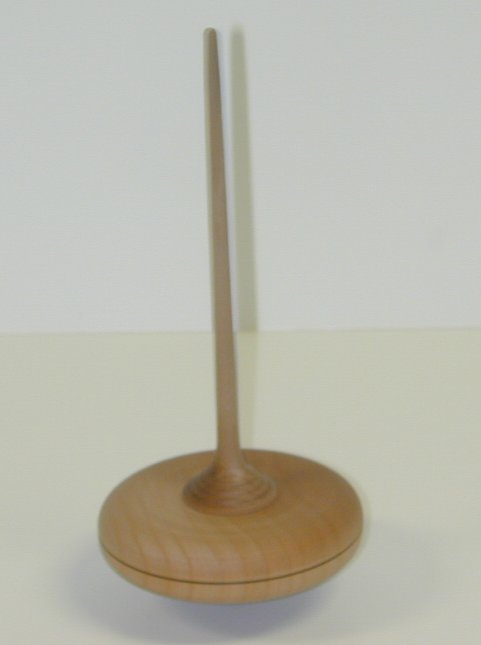 Peonza de madera clara, con el cuerpo más grueso y redondeado.